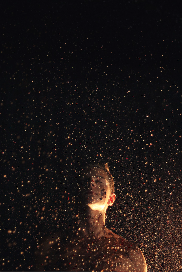 Person surrounded by starry sky.